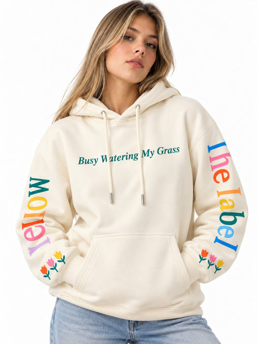 Hoodie de dama marfil, modelo mujer con letras multicolor en mangas y frase verde en pecho