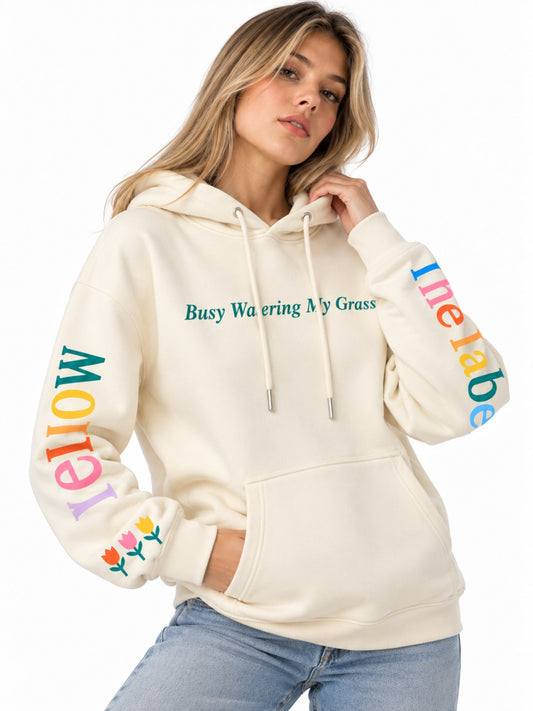 Hoodie marfil para dama Busy Watering My Grass, vista frontal con diseños de flores y letras de colores